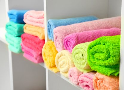 colorful towels on shelves in bathroom