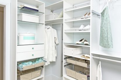 Declutter your closet: detail of large organized walk-in closet with modern wardrobe on hangers