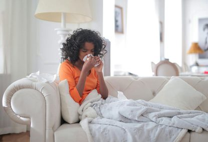 Organization for cold and flu season - woman on a couch with a cold